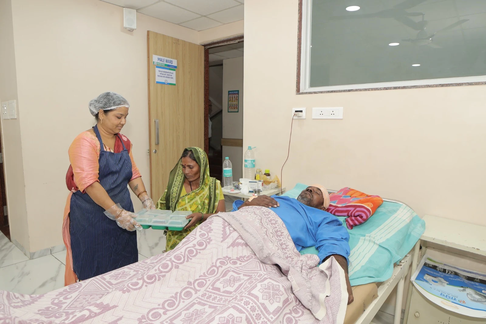 Hospital staff member assisting a patient at the bedside
