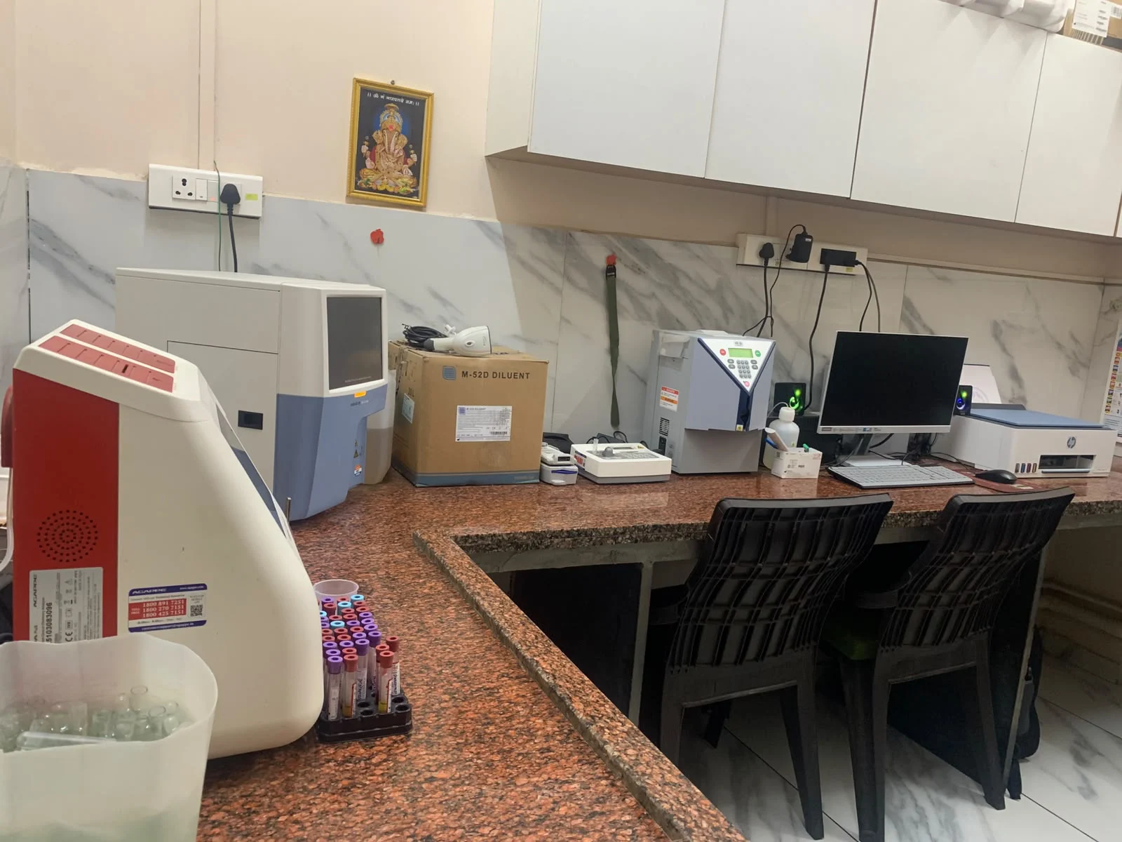 Laboratory testing analysers and sample workspace at Deccan Malti Hospital